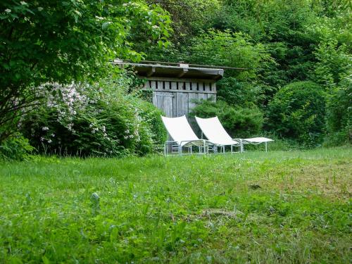 two white chairs sitting in a field of grass at Minimalist Style Apartment In Upper Palatinate in Neunburg vorm Wald