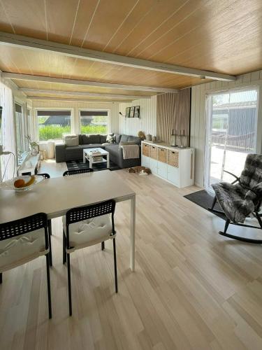 a large living room with a table and chairs at Protected Fjord Cabin With Fjord Views in Randers