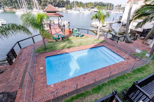 an overhead view of a swimming pool next to the water at Mzingazi Waterfront Accommodation, On The Bay Waterfront Villa's in Richards Bay