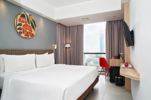 Postel nebo postele na pokoji v ubytování Neo Hotel Puri Indah