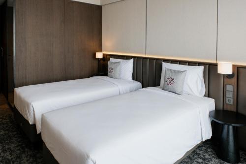 two beds sitting next to each other in a hotel room at Manon Boutique Hotel Kota Lama Semarang in Semarang