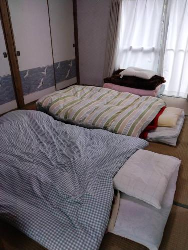 Postel nebo postele na pokoji v ubytování 古民家のお宿ふうす