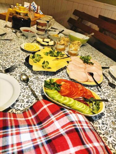 een tafel met borden vlees en groenten erop bij Willa 7 in Korbielów