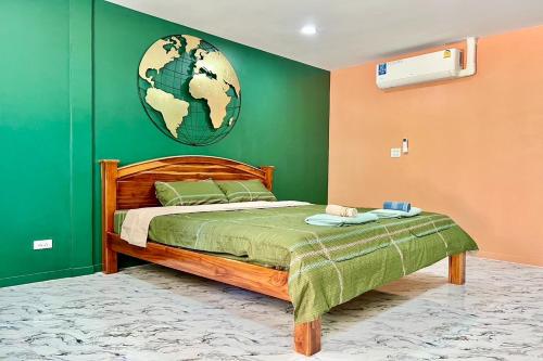 a bedroom with a bed with a green wall at Koon Hom Apartment in Ban Dung