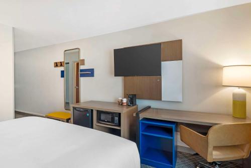 a hotel room with a bed and a desk and a tv at Comfort Inn Monticello in Charlottesville