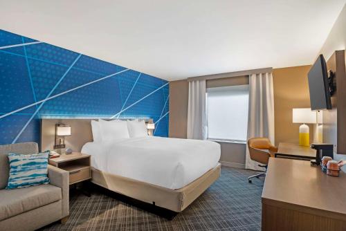 a hotel room with a large bed and a chair at Comfort Inn Monticello in Charlottesville