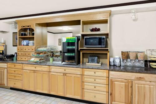 une grande cuisine avec des placards en bois et un four micro-ondes dans l'établissement Quality Inn Mount Vernon, à Mount Vernon