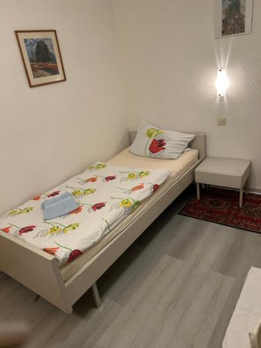 a bedroom with a bed with a white bedspread with flowers on it at Hotel Haus Schwan Köln in Cologne