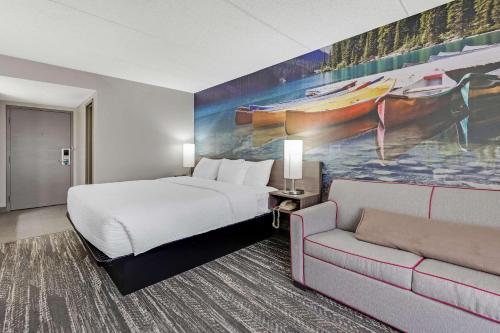 a hotel room with a bed and a couch at Clarion Pointe Near Erie Casino in Erie