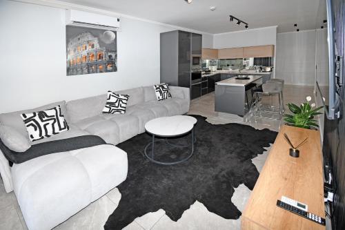 a living room with a couch and a table at Thango Res Ellipse Waterfall. in Midrand