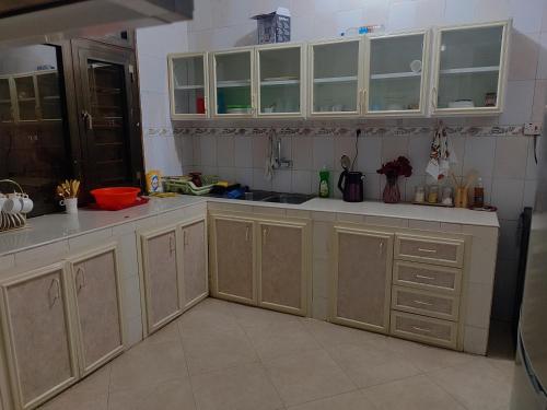 a kitchen with white cabinets and a sink at Rotaja Luxury Apartment in Tomondo