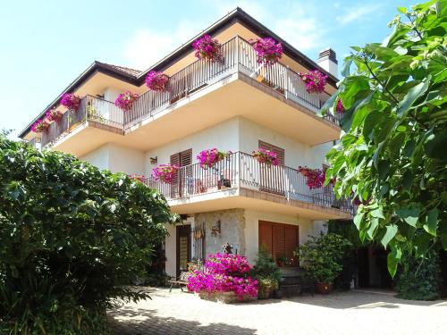 una casa con fiori rosa sui balconi di Agriturismo Nonno Tobia ad Agerola
