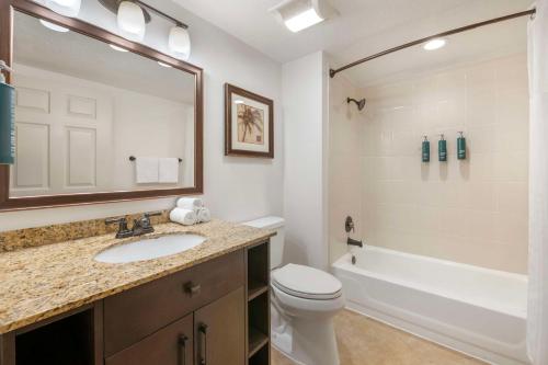 a bathroom with a sink and a toilet and a tub at Hilton Vacation Club Aqua Sol Orlando West in Orlando