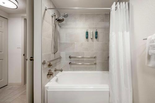 a bathroom with a white tub and a shower at Hilton Vacation Club Aqua Sol Orlando West in Orlando