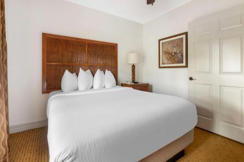 a white bedroom with a large white bed and a door at Hilton Vacation Club Aqua Sol Orlando West in Orlando
