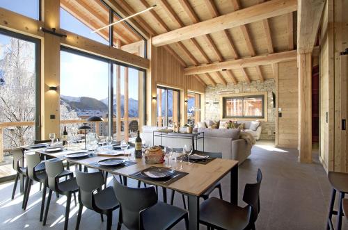 une salle à manger avec une longue table et des chaises dans l'établissement Odalys Chalet Le Télémark, à Les Deux Alpes