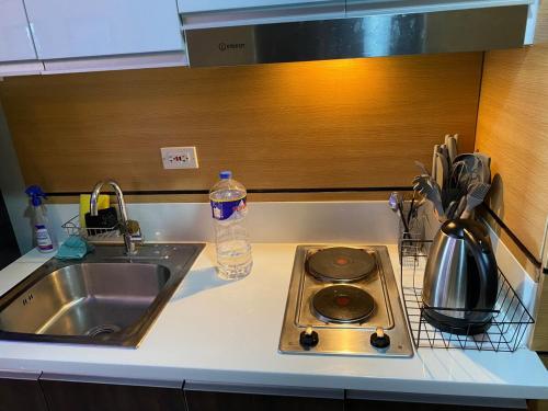 a kitchen counter top with a sink and a sink at Makati Ayala luxury Stylish Uncle Sam condo Gym Swim Park 300 Mb 2641 in Manila