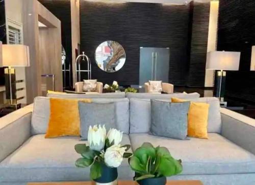 a living room with a blue couch and yellow pillows at Makati Ayala luxury Stylish Uncle Sam condo Gym Swim Park 300 Mb 2641 in Manila