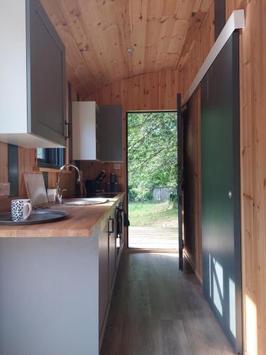 Il comprend une cuisine avec des plafonds en bois et une porte donnant sur une cour. dans l'établissement Roulotte, à Cassagnes-Bégonhès