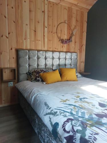 un lit dans une chambre avec un mur en bois dans l'établissement Roulotte, à Cassagnes-Bégonhès