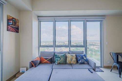 a large couch in a room with a large window at Luxury Corner Suite 1 Bedroom plus Den Top Floor Birds Eye View Spacious 668 square Feet in Iloilo City