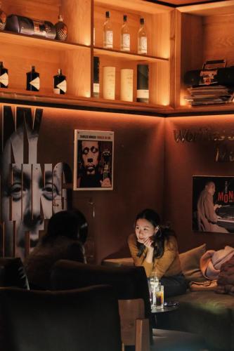 a woman sitting in a bar talking on a cell phone at CLASSYC Hotel in Hanoi