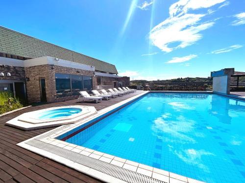 a large swimming pool with lounge chairs on a building at Mikazuki Sea-Park Hotel Katsuura in Katsuura