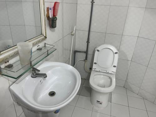 a white bathroom with a sink and a toilet at Hồng Phát 68 Hotel in Ho Chi Minh City