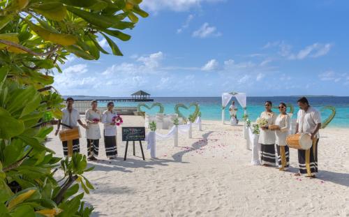 a group of people standing on a beach at Adaaran Select Meedhupparu - with Dine around Premium All inclusive - 24 hours in Meedhoo