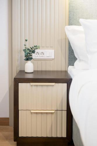 a small table with a plant on it next to a vase at Hotel Dumbrava in Rupea