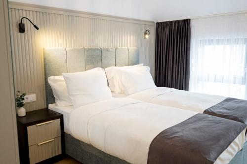 a large white bed in a hotel room at Hotel Dumbrava in Rupea