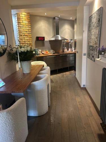 - une cuisine avec une table en bois et des chaises blanches dans l'établissement Catalans flat, à Marseille
