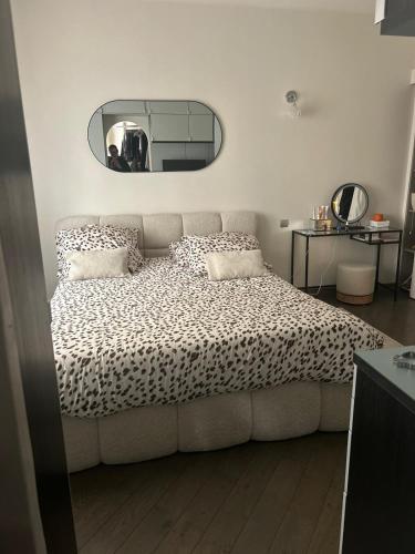 une chambre avec un grand lit avec un miroir dans l'établissement Catalans flat, à Marseille