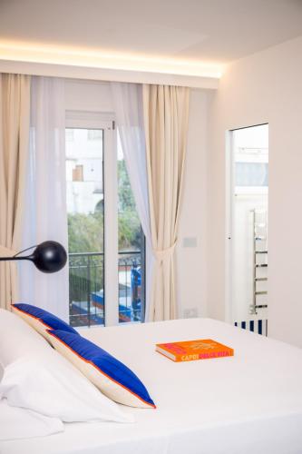 a bed with a book and a lamp on it at Pepella in Piano di Sorrento