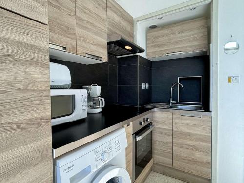 une cuisine avec un lave-linge et un sèche-linge sur un comptoir dans l'établissement Appartement 2 pièces 4 couchages ARGELES SUR MER AR680-0E4, à Argelès-sur-Mer