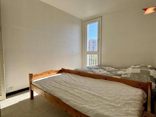 une chambre avec un lit et une fenêtre dans l'établissement Appartement 2 pièces 4 couchages ARGELES SUR MER AR680-0E4, à Argelès-sur-Mer