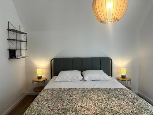 une chambre avec un grand lit avec deux lampes dans l'établissement Marcq en Baie, appartement neuf, à Saint-Valery-sur-Somme