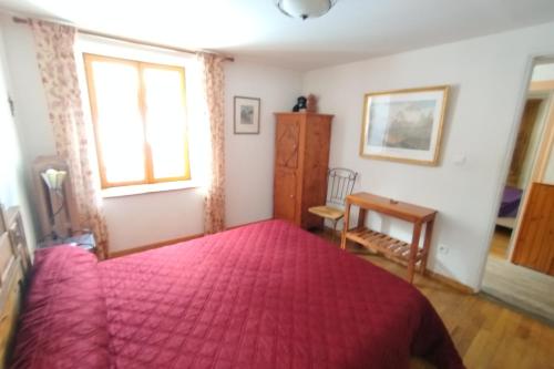 - une chambre avec un lit rouge et un bureau dans l'établissement Room for two in a house of the XVII century - N2 Chez Jean Pierre, à Villar-dʼArêne