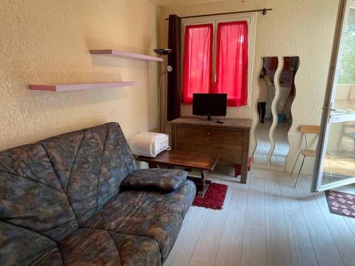 - un salon avec un canapé et une fenêtre rouge dans l'établissement Studio 2 couchages ARGELES SUR MER AR450-0404, à Argelès-sur-Mer