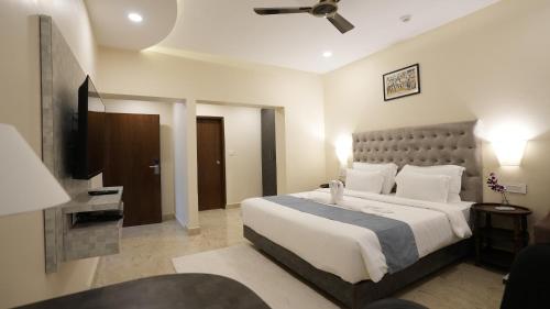 a bedroom with a large bed and a flat screen tv at The Verda De Miranda Resort Morjim North Goa in Morjim