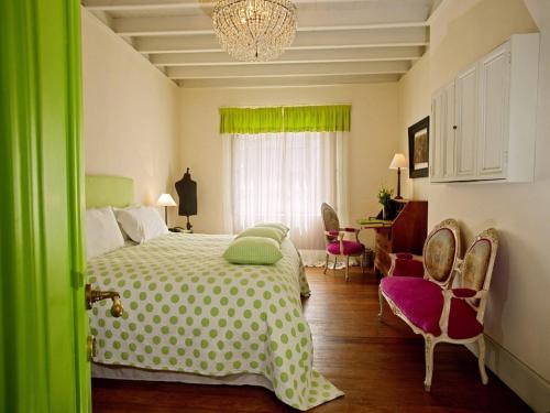 a bedroom with a bed and chairs and a chandelier at Quinta Miraflores Boutique Hotel in Lima
