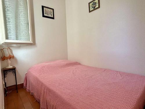 - une chambre avec un lit rose et une fenêtre dans l'établissement Studio cabine 3 couchages ARGELES SUR MER AR020-043, à Argelès-sur-Mer