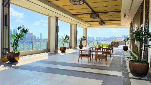 a room with tables and chairs and large windows at Jungle Escape in Manila