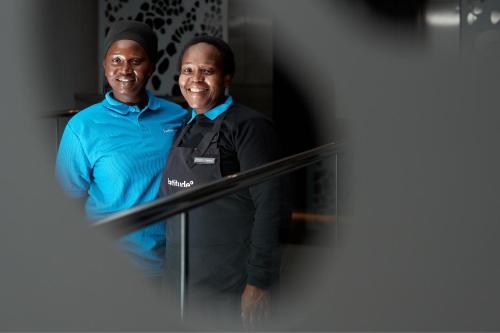 two men are standing next to each other at Latitude Aparthotel by Totalstay in Cape Town