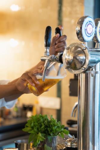a person is pouring a drink from a juicer at Latitude Aparthotel by Totalstay in Cape Town