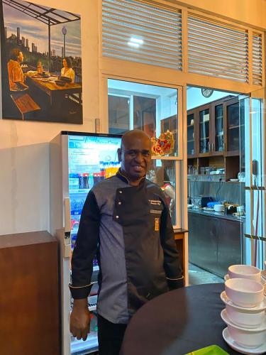 a man standing in front of a table with plates at The Den 23 in Maradana