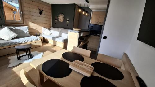 un salon avec une table et un canapé dans l'établissement Résidence Ellebore - Appartement cosy et lumineux coeur de station MAE-5791, à Aime La Plagne
