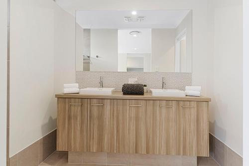 ダンズボローにあるLuxury 4 bedroom Dunsborough Retreatの洗面台が2つと大きな鏡があるバスルーム
