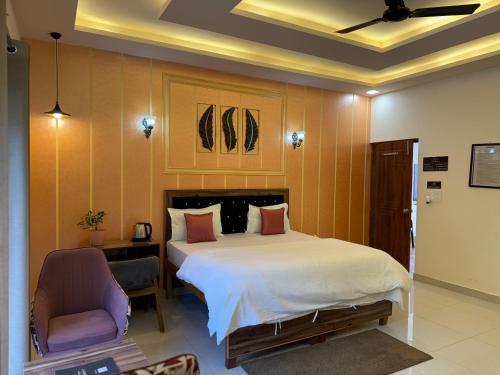 a bedroom with a large bed and a chair at Rootz in Dehradun