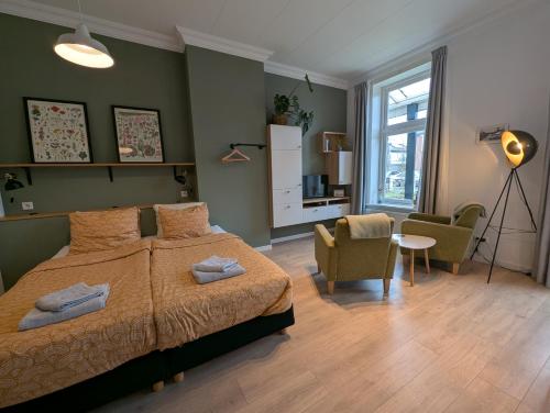 a bedroom with a bed and a living room at B&B TxL in De Cocksdorp